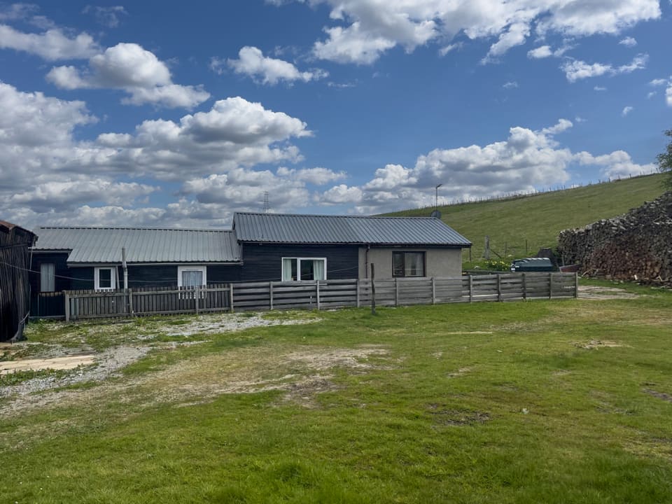The bungalow and timber outbuildings from the yard