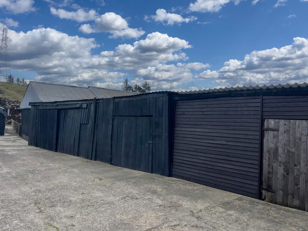 Timber outbuildings and garages along the track