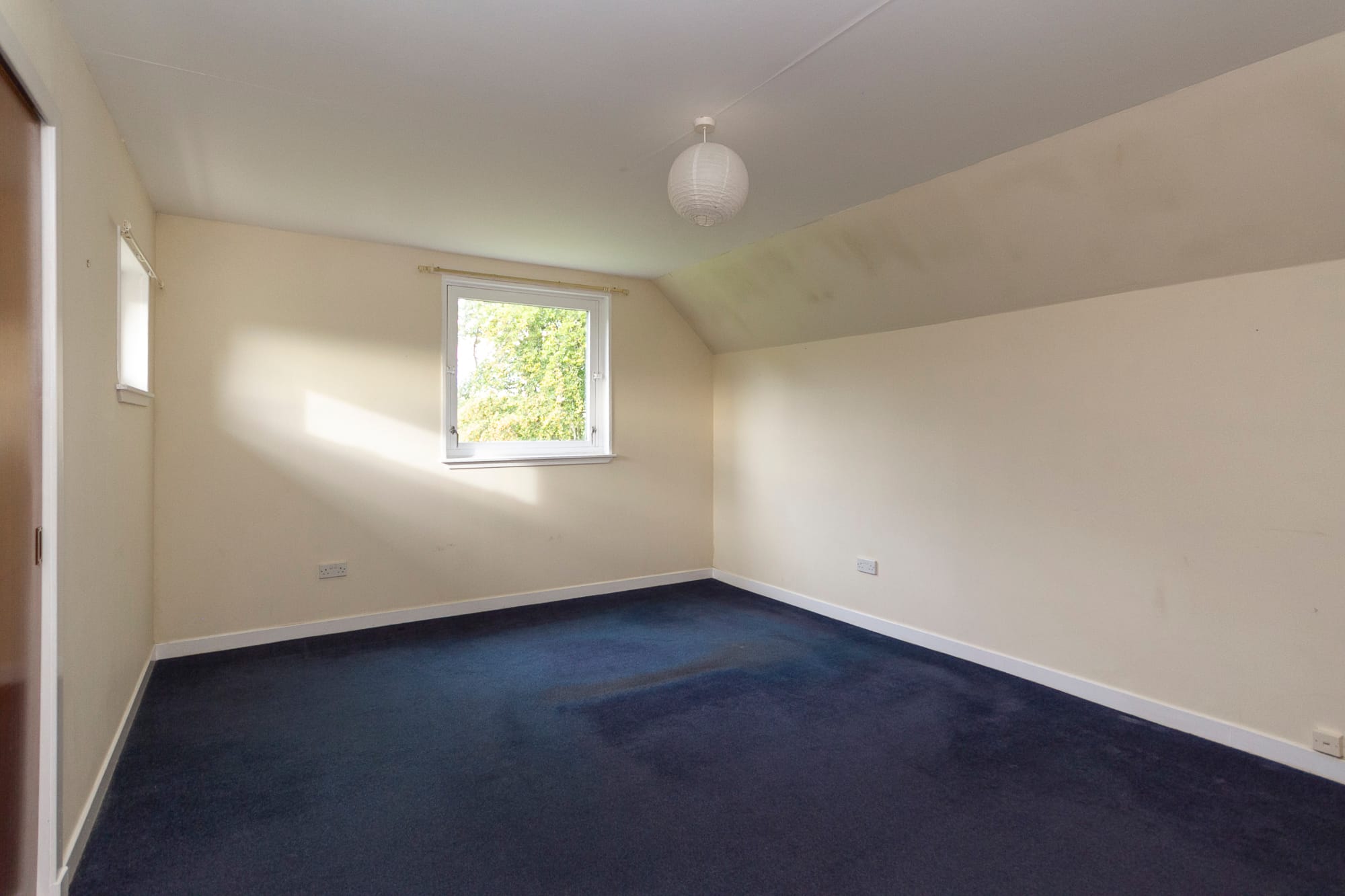 A bedroom with a window to the garden