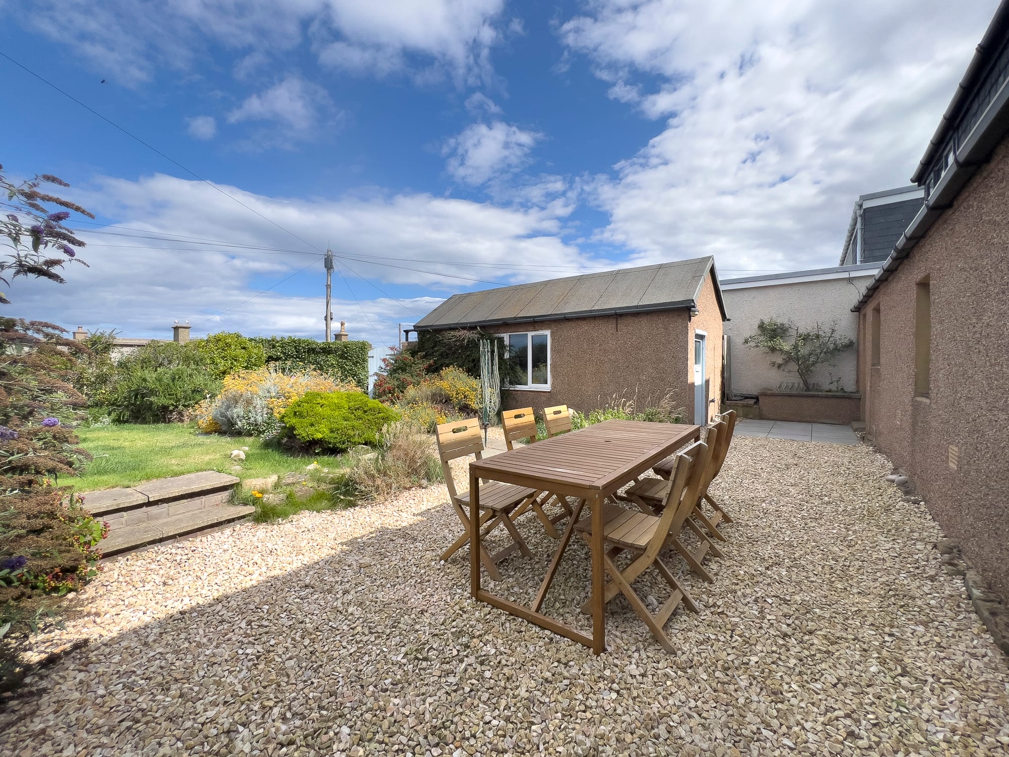 Enclosed rear garden with lawn and a table set out — Dunbar Street, Burghead